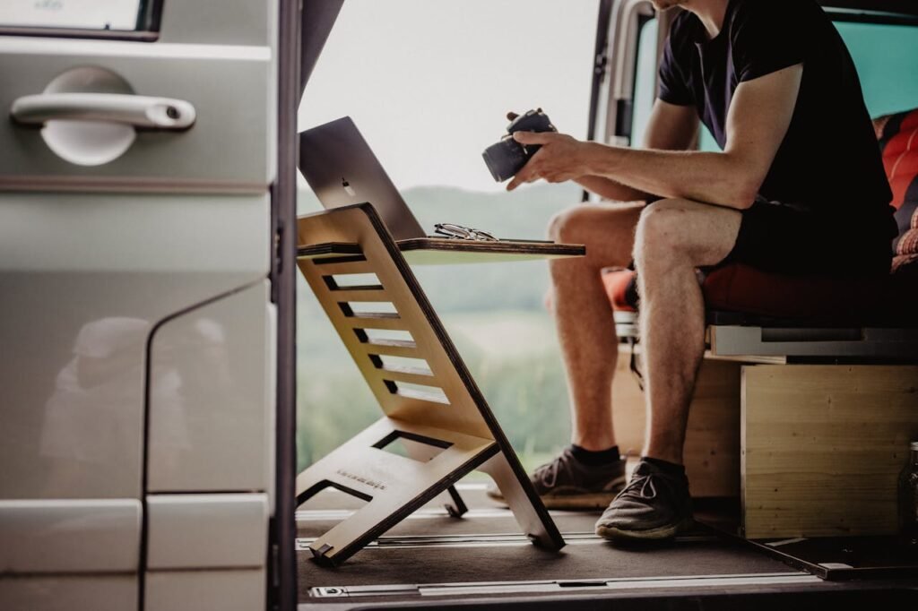 Man Sitting in a Van and Working on a Laptop